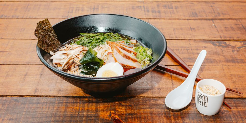 A bowl of food with chopsticks on a wooden table